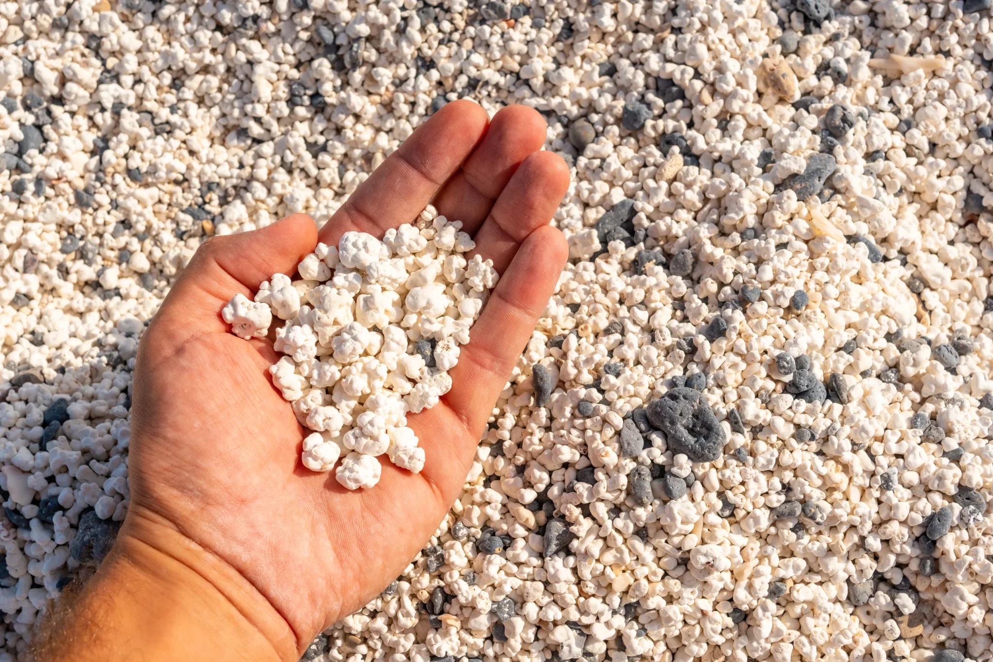 Detalle de una mano sosteniendo un puñado de arena de la Playa de El Hierro, en Fuerteventura.